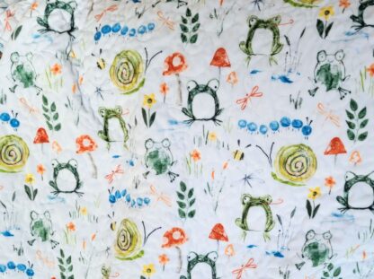 soft minky back of baby quilt with frogs, snails, mushrooms, leaves on white background