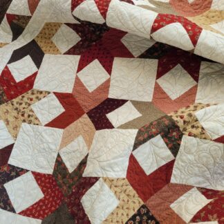 scrappy star throw quilt in brown, red and beige cotton fabrics